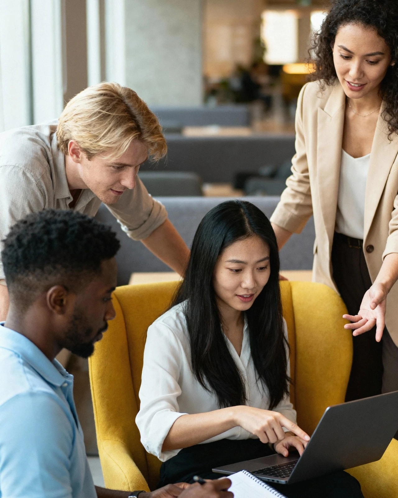 A team collaborating around a laptop