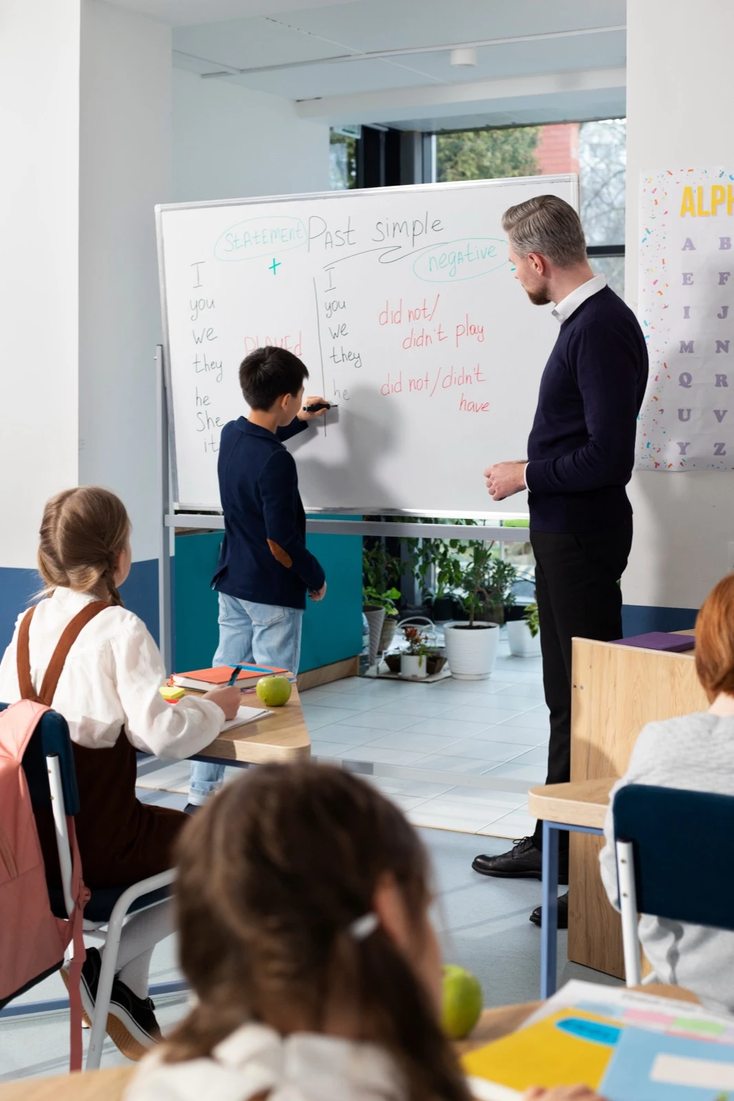 Teacher and student working through a lesson at a classroom whiteboard